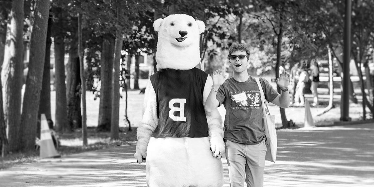 The Bowdoin Polar Bear and a helpful student guide watch games at Pickard Field.