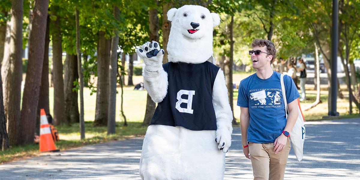 The Bowdoin Polar Bear and a helpful student guide watch games at Pickard Field.